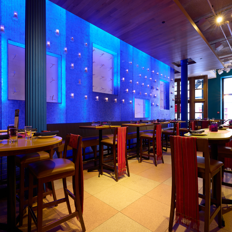 Rosa Mexicano Lincoln Center dining room with an illuminated blue-tiled water wall and set tables.