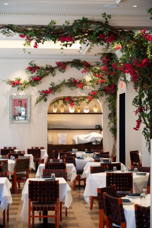 Interior corproate party room at Rosa Mexicano, with white stucco walls, tables with white table cloths and christmast decorations