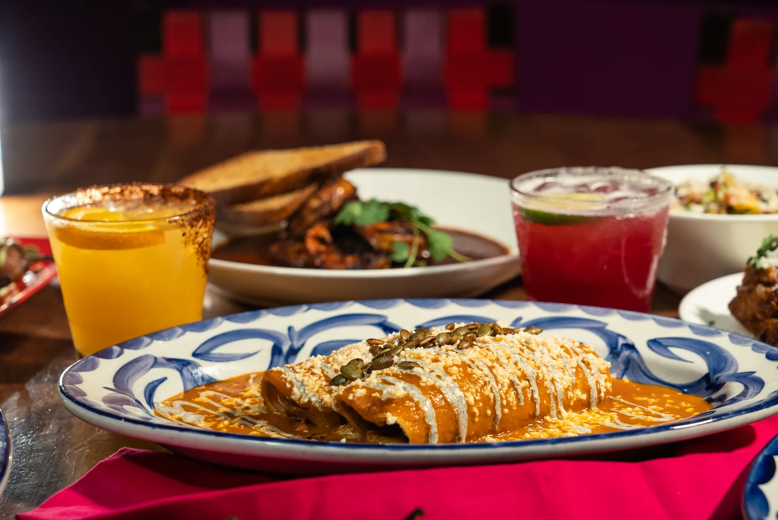 Butternut Squash and Carnitas Enchiladas with charred scallion crema and toasted pepitas at Rosa Mexicano