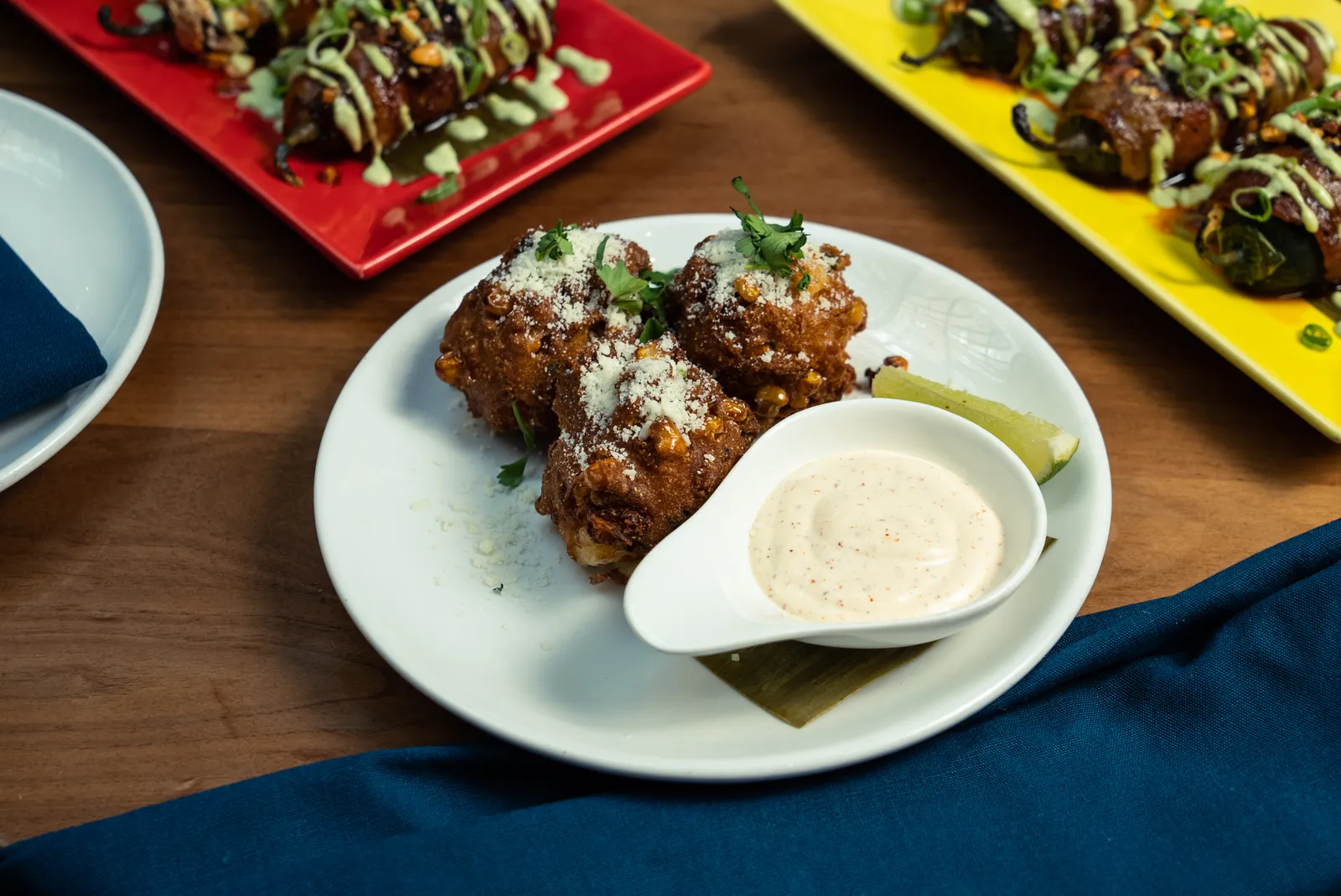 Elote fritters with Tajín-lime crema and a lime wedge, from the Rosa Mexicano A Taste of Fall menu